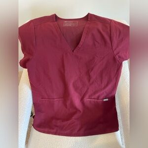 FIGS maroon v neck scrub top with two pockets in the front